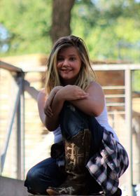 Portrait of smiling girl sitting outdoors