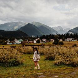 Rear view of girl standing on landscape against sky