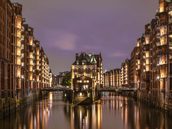 River amidst illuminated buildings in city at night