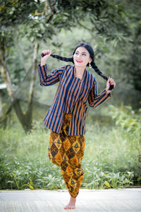 Portrait of smiling young woman standing on field