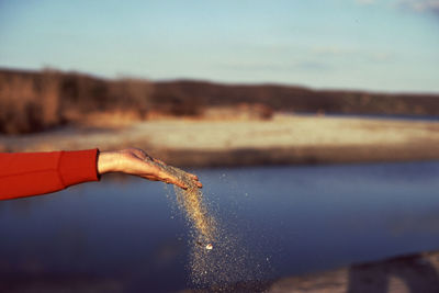 Hand and sand nearby sea