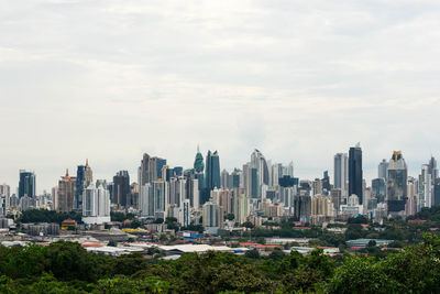 View of buildings in city against cloudy sky