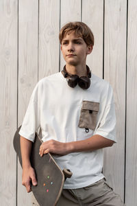 Portrait of boy standing against wall