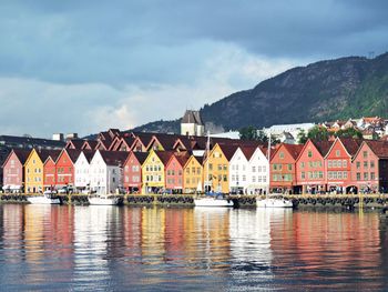 Buildings by lake against sky