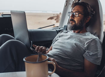 Man using laptop in camper van