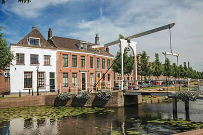 Canal with brick houses and bascule bridge in weesp. a pleasant small village in netherlands.