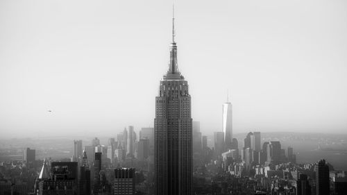 Empire state building with cityscape against sky
