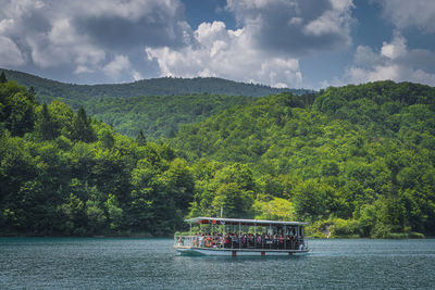 Scenic view of trees by river against sky