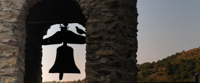 Low angle view of silhouette tree against building