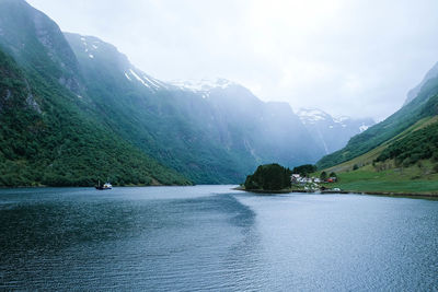 Scenic view of river and mountains against sky