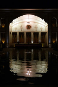 Reflection of illuminated building in water at night