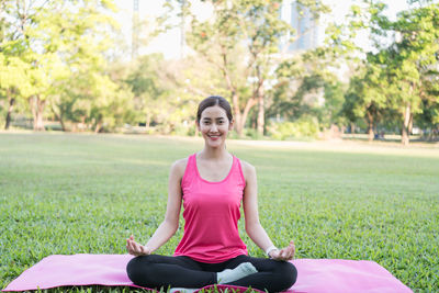 Portrait of a smiling young woman sitting on grass