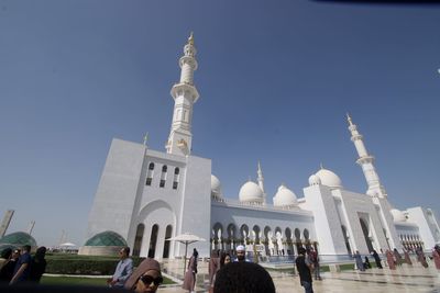 Group of people in front of historic building against sky