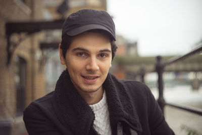 Portrait of smiling man in city during winter