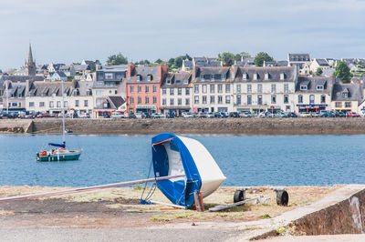 People by sea against buildings in city