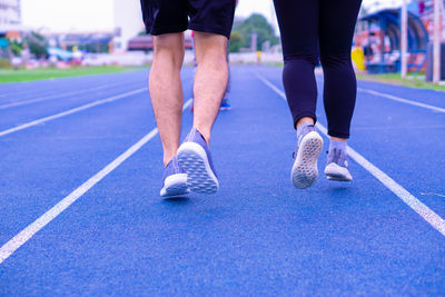 Low section of people running on sports track