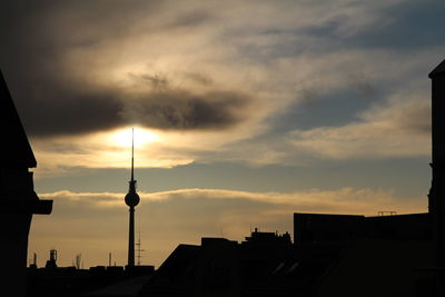 Silhouette of buildings against cloudy sky