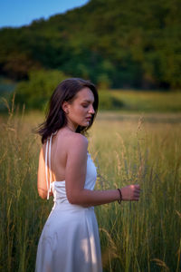 Side view of young woman standing on field