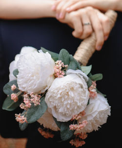 Close-up of hand holding white roses