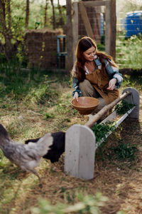 Side view of woman sitting on field