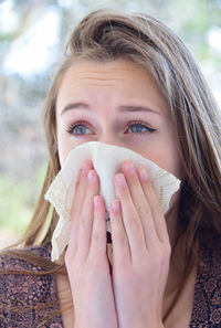 Seasonal allergies, young woman sneezing handkerchief