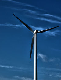 Low angle view of windmill against blue sky