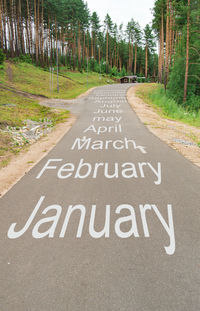 The name of the month is written on the highway in the middle of an empty asphalt road 