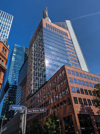 Low angle view of modern buildings against blue sky