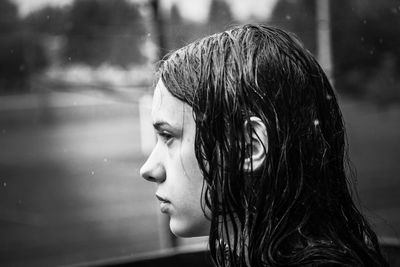 Young woman looking away through glass window