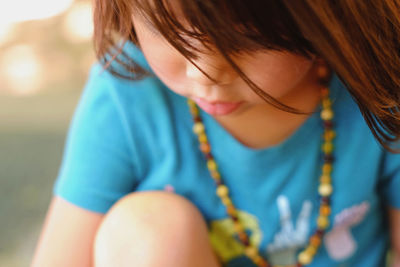 Close-up of girl sitting outdoors