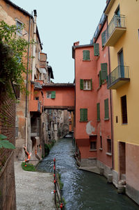 Canal amidst buildings in town against sky