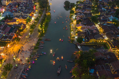 High angle view of illuminated street amidst buildings at night