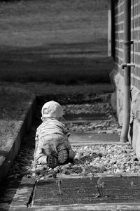 Rear view of boy sitting outdoors