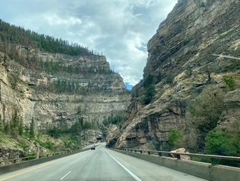 Road leading towards mountains against sky