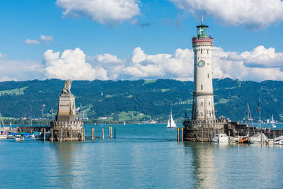 Lighthouse by sea against sky