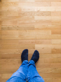 Low section of person standing on hardwood floor