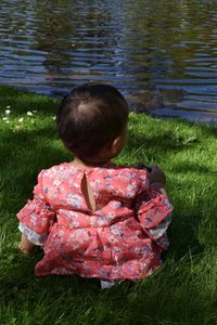 Rear view of girl with lake in grass