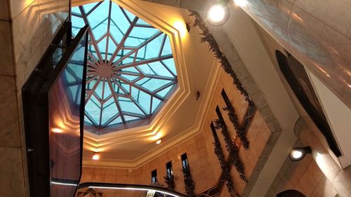 Low angle view of illuminated lights hanging on ceiling in building