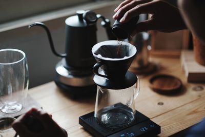 Barista drip coffee in morning on wood table with vintage decorations interior design