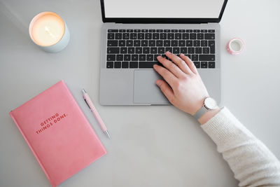 Midsection of woman using smart phone on table