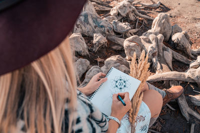Low section of woman holding text on land