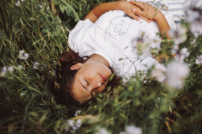 Portrait of woman lying on grassy field