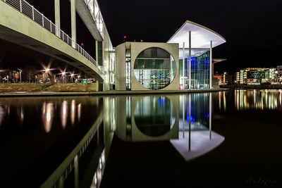 Illuminated bridge over river at night