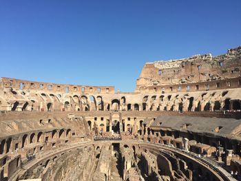 Low angle view of old ruins against clear blue sky