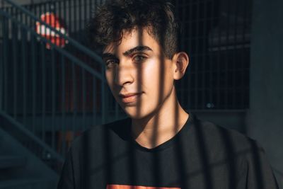 Portrait of young man standing against wall