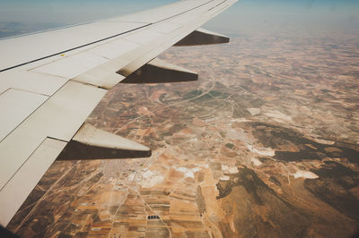 Cropped image of airplane flying over clouds