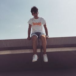 Full length of man sitting against sky