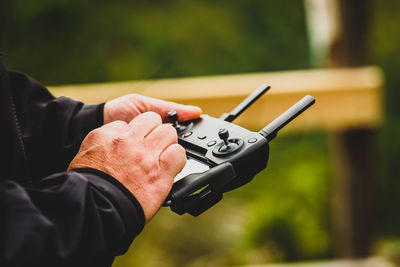 Cropped hands of man using remote control