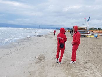 People standing on beach against sky