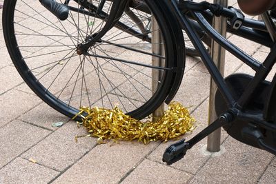 Black bicycle in city adorned with golden garland